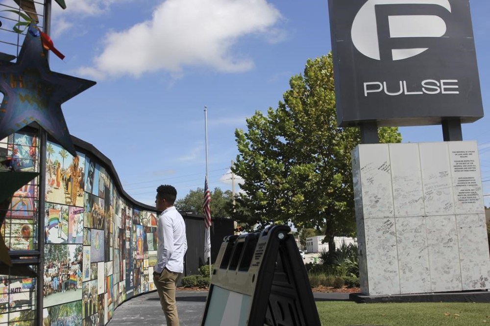 FILE - Brandon Wolf, a survivor of the Pulse nightclub shooting and activist, looks at the photos that are a part of the Pulse memorial in Orlando, Fla., on Sept. 9, 2022. The city of Orlando plans to purchase the gay nightclub property where 49 people were massacred seven years ago, in what at the time was the deadliest mass shooting in modern U.S. history, with the intention of building a memorial for the victims, Mayor Buddy Dyer said Wednesday, Oct. 18, 2023. (AP Photo/Cody Jackson, file)