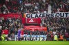 Manchester United fans hold up banners against the current owners of the club the Glazers as players enter to the pitch for the English Premier League soccer match between Manchester United and Crystal Palace at the Old Trafford stadium stadium in Manchester, England, Saturday, Sept. 30, 2023. (AP Photo/Jon Super)