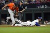 Texas Rangers' Marcus Semien, right, is tagged out by Houston Astros first baseman Jose Abreu while diving back to first base during the fifth inning in Game 4 of the baseball American League Championship Series Thursday, Oct. 19, 2023, in Arlington, Texas. (AP Photo/Julio Cortez)