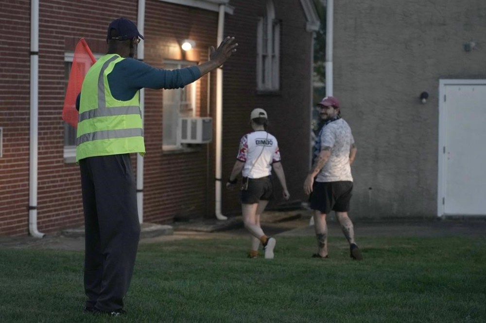 Reginald Rawls waves to people as they leave the Calvary Baptist Church parking lot and walk to the Philadelphia Union's Subaru Park for a soccer game, Wednesday, Oct. 4, 2023, in Chester, Pa. (AP Photo/Michael Perez)
