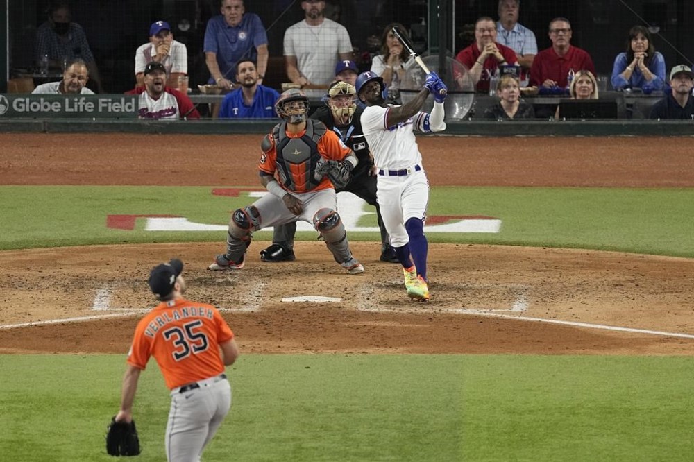 Texas Rangers' Adolis Garcia, right, watches his three-run home run along with Houston Astros starting pitcher Justin Verlander (35) and catcher Martin Maldonado during the sixth inning in Game 5 of the baseball American League Championship Series Friday, Oct. 20, 2023, in Arlington, Texas. (AP Photo/Tony Gutierrez)