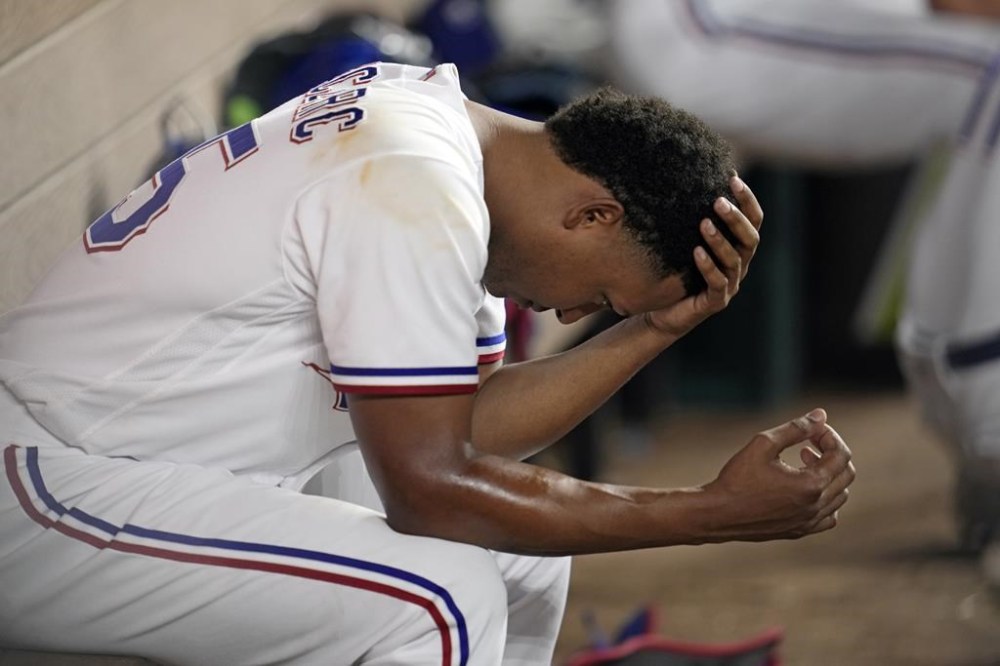 Texas Rangers relief pitcher Jose Leclerc sits dejected in the dugout during the ninth inning in Game 5 of the baseball American League Championship Series Friday, Oct. 20, 2023, in Arlington, Texas. Leclerc gave up a three-run home run to Houston Astros' Jose Altuve and the Astros won 5-4. (AP Photo/Godofredo A. Vásquez)