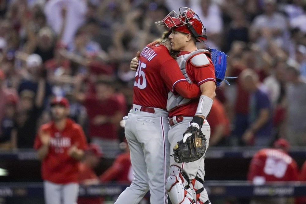Philadelphia Phillies relief pitcher Matt Strahm and catcher J.T. Realmuto celebrate their win against the Arizona Diamondbacks in Game 5 of the baseball NL Championship Series in Phoenix, Saturday, Oct. 21, 2023. (AP Photo/Ross D. Franklin)