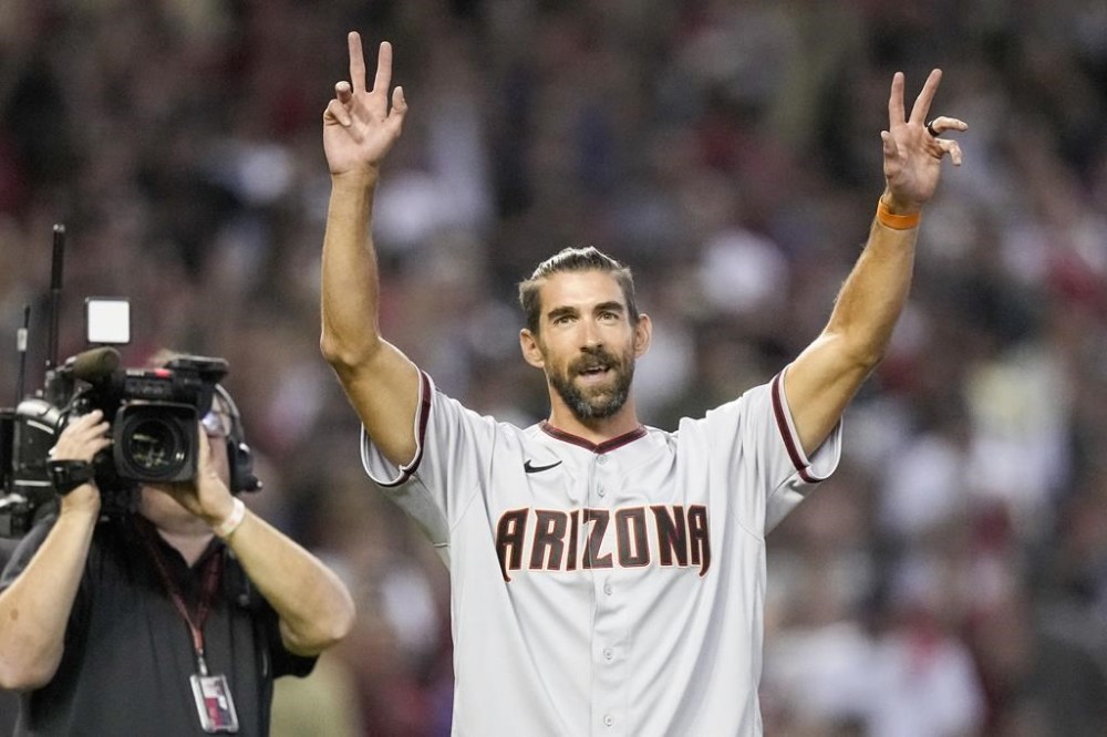 Swimmer, Michael Phelps throws out the ceremonial first pitch before Game 5 of the baseball NL Championship Series between the Philadelphia Phillies and the Arizona Diamondbacks in Phoenix, Saturday, Oct. 21, 2023. (AP Photo/Brynn Anderson)