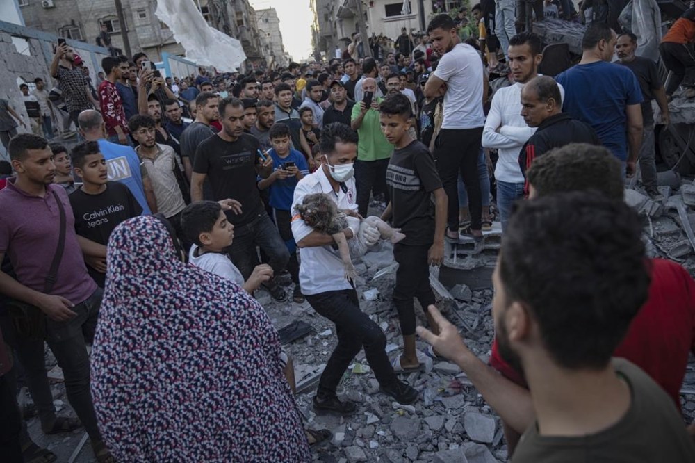 A child is carried from the rubble of a building after an airstrike in Khan Younis, Gaza Strip, Saturday, Oct. 21, 2023. (AP Photo/Fatima Shbair)