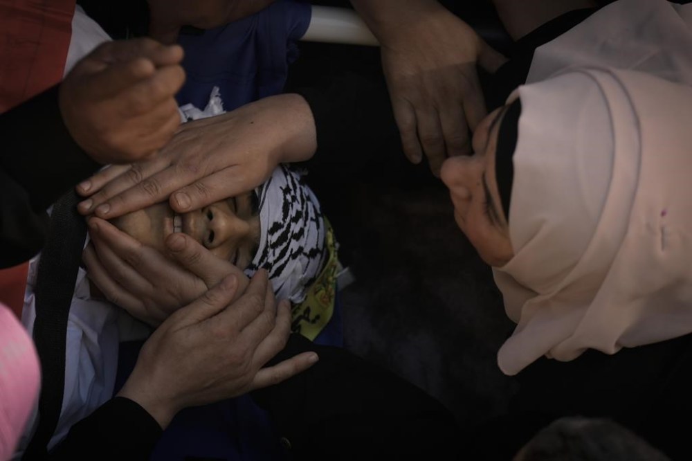 Palestinian mourners gather around the body of Oday Mansour, 17, during his funeral in the West Bank village of Kafr Qallil, Saturday, Oct. 21, 2023. Mansour was killed in clashes with Israeli forces Friday during a protest in support of the Gaza Strip, at a military checkpoint in the flash point town of Hawara, West Bank. (AP Photo/Majdi Mohammed)