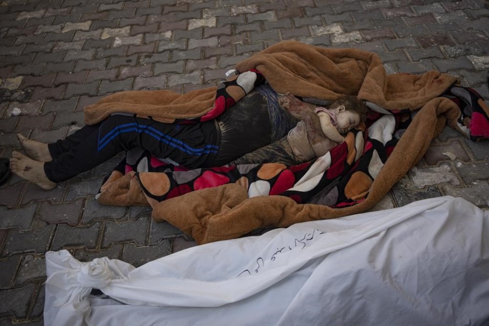 The bodies of a father and his child killed in the Israeli bombardment of the Gaza Strip, lie in front of the morgue at Al-Aqsa Hospital in Deir Al-Balah, Sunday, Oct. 22, 2023. ( AP Photo/Fatima Shbair)