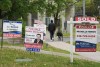 Many Canadian homeowners are facing sticker shock with their monthly payments as their mortgage comes up for renewal, leaving them with a crucial choice: whether to renew or refinance their home loan. A person walks past multiple for-sale and sold real estate signs in Mississauga, Ont., on Wednesday, May 24, 2023. THE CANADIAN PRESS/Nathan Denette