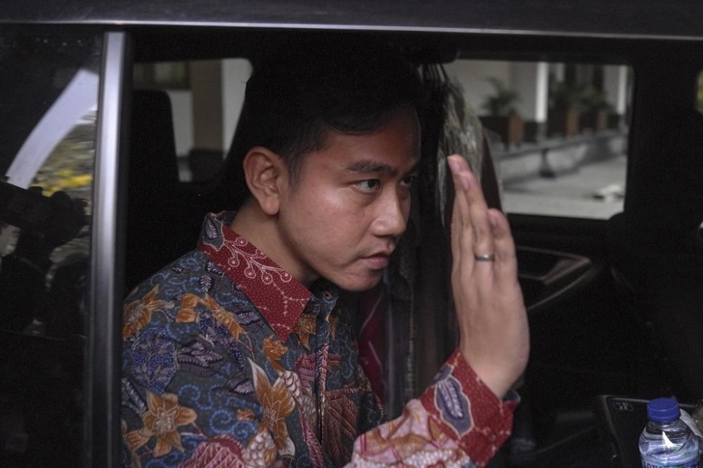Gibran Rakabuming Raka, the Surakarta city mayor who is also the eldest son of Indonesian President Joko Widodo, waves to reporters as he leaves his office in Surakarta, Central Java, Indonesia, Monday, Oct. 23, 2023. Indonesia's leading presidential hopeful, former special forces general Prabowo Subianto named Gibran Rakabuming Raka, the outgoing president's eldest son, as his running mate in next year's election in Southeast Asia's largest democracy. (AP Photo/Hisyam Umar)