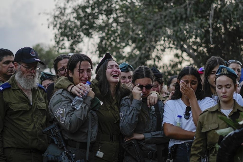 Mourners gather around the graves of Sgt. Yam Goldstein and her father, Nadav, during their funeral in Kibbutz Shefayim, Israel, Monday, Oct. 23, 2023. Yam and her father were killed by Hamas militants on Oct. 7 at their house in Kibbutz Kfar Azza near the border with the Gaza Strip. The rest of the family are believed to be held hostage in Gaza. More than 1,400 people were killed and some 200 captured in an unprecedented, multi-front attack by the militant group that rules Gaza. (AP Photo/Ariel Schalit)