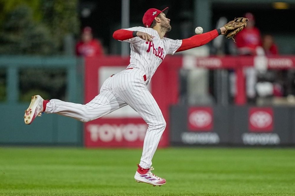 Philadelphia Phillies shortstop Trea Turner can't get a glove on a hit by Arizona Diamondbacks' Corbin Carroll during the fifth inning in Game 6 of the baseball NL Championship Series in Philadelphia Monday, Oct. 23, 2023. (AP Photo/Brynn Anderson)