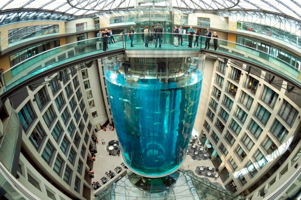 FILE - People gather on the top of the AquaDom aquarium at the Sea Life tourist attraction in Berlin, on July 27, 2015. Prosecutors in Berlin say they have closed their investigation into the spectacular collapse of a huge aquarium last December after an expert report failed to pin down a reason why the tank burst. The AquaDom aquarium, which stood in a hotel lobby, burst in the early hours of Dec. 16, sending 1 million liters (264,000 gallons) of water gushing into the building and the street outside. (Joerg Carstensen via DPA, File)