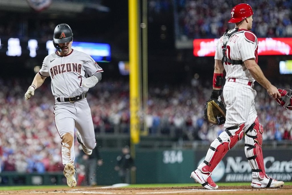 Arizona Diamondbacks' Corbin Carroll scores on a hit by Arizona Diamondbacks' Christian Walker against the Philadelphia Phillies during the first inning in Game 7 of the baseball NL Championship Series in Philadelphia Tuesday, Oct. 24, 2023. (AP Photo/Brynn Anderson)
