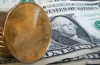 A loonie sits on American dollar bills on Sept. 20, 2007 in Montreal. The Canadian dollar has dipped against the US dollar following the Bank of Canada's decision to hold its key interest rate at five per cent. THE CANADIAN PRESS/Paul Chiasson