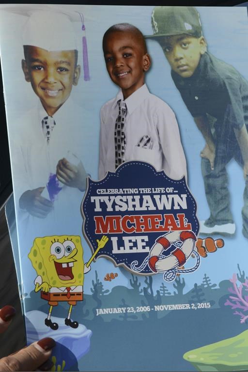 FILE - In this Nov. 10, 2015, file photo, a mourner holds the program for the funeral of 9-year-old Tyshawn Lee at St. Sabina Church in Chicago. A Chicago father has been convicted of attempting to kill three people to avenge the slaying of his 9-year-old son who was lured from a playground into an alley with the promise of a juice box by rival gang members in 2015 and shot. A jury deliberated several hours Wednesday, Oct. 26, 2023 before finding Pierre Stokes, 33, guilty of attempted murder, aggravated battery with a firearm and a gun charge. (Brian Jackson/Chicago Sun-Times via AP, File)