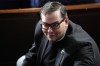FILE - Rep. George Santos, R-N.Y., watches on the House floor at the Capitol in Washington, Oct. 25, 2023. Santos is set to be arraigned on a revised indictment accusing him of several frauds, including making tens of thousands of dollars in unauthorized charges on credit cards belonging to his campaign donors. (AP Photo/Alex Brandon, File)