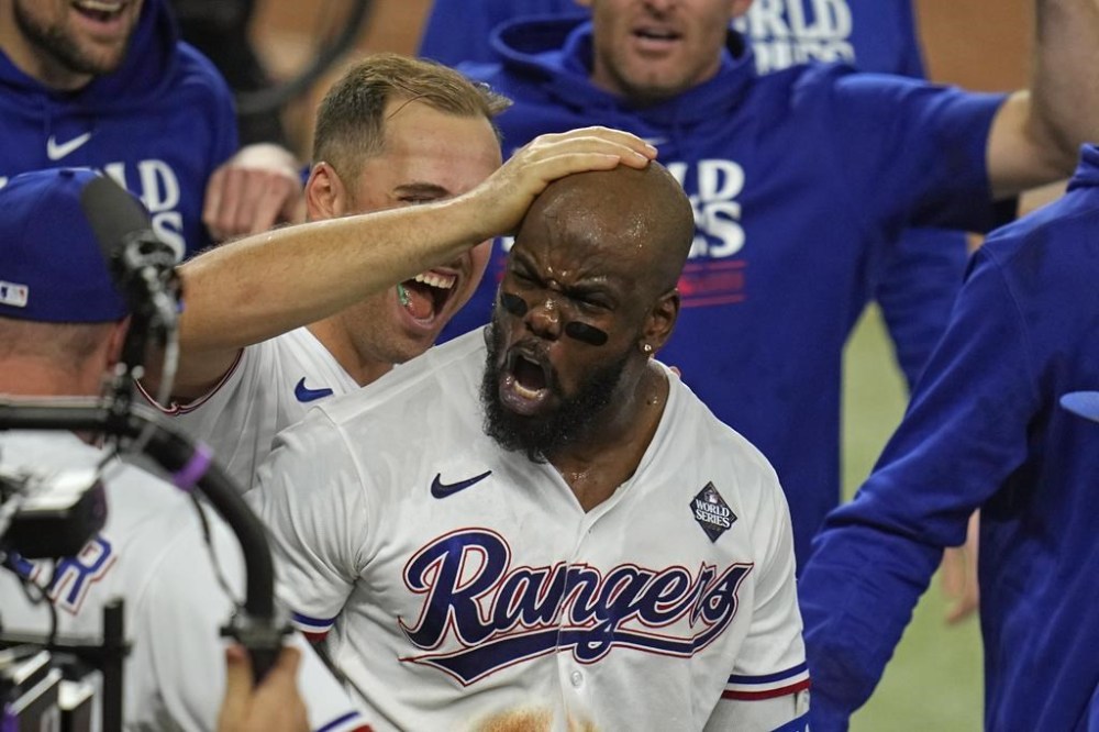 Texas Rangers' Adolis Garcia celebrates with teammates after hitting a game-winning home run against the Arizona Diamondbacks during the 11th inning in Game 1 of the baseball World Series, Friday, Oct. 27, 2023, in Arlington, Texas. (AP Photo/Julio Cortez)