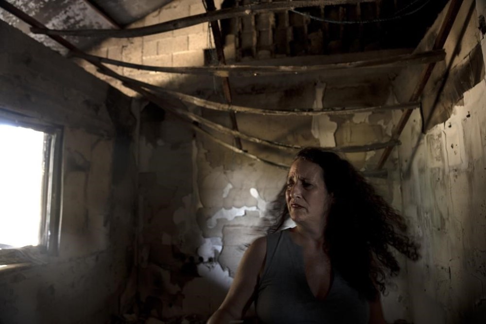 Hadas Calderon is overcome by emotion in the ruins of her mother's home in Kibbutz Nir Oz, southern Israel, Monday, Oct. 30, 2023. The kibbutz was overran by Hamas on Oct. 7, killing or capturing a quarter of its community, including Carmela Dan, Calderon's mother 80, and niece, Noya, 12. Her children Erez, 12, Sahar, 16, and Ofer, 53, the children's father are in Gaza. (AP Photo/Maya Alleruzzo)