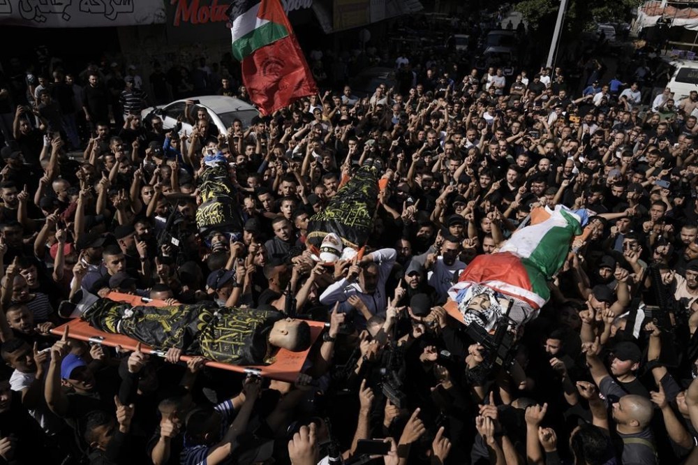 Palestinians Carry bodies of militants killed in clashes during an Israeli rad in Jen refugee camp in the West Bank on Monday, Oct. 30, 2023. (AP Photo/Majdi Mohammed)