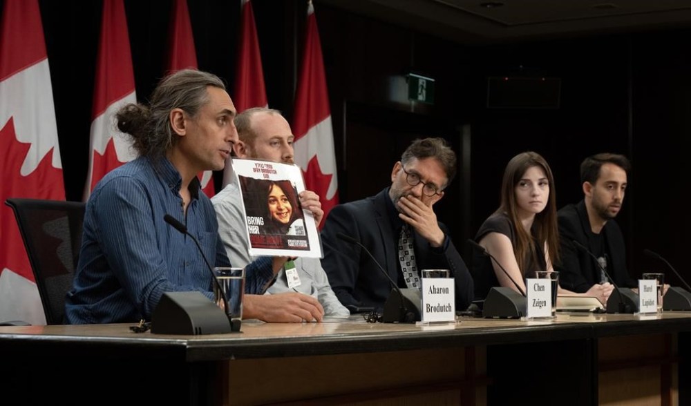 Chen Zeigen, Harel Lapidot, Alexandra Friedman and Itay Raviv (right) listen to Aharon Brodutch as he speaks about a family member who was taken hostage by Hamas, Monday, October 30, 2023 in Ottawa. THE CANADIAN PRESS/Adrian Wyld