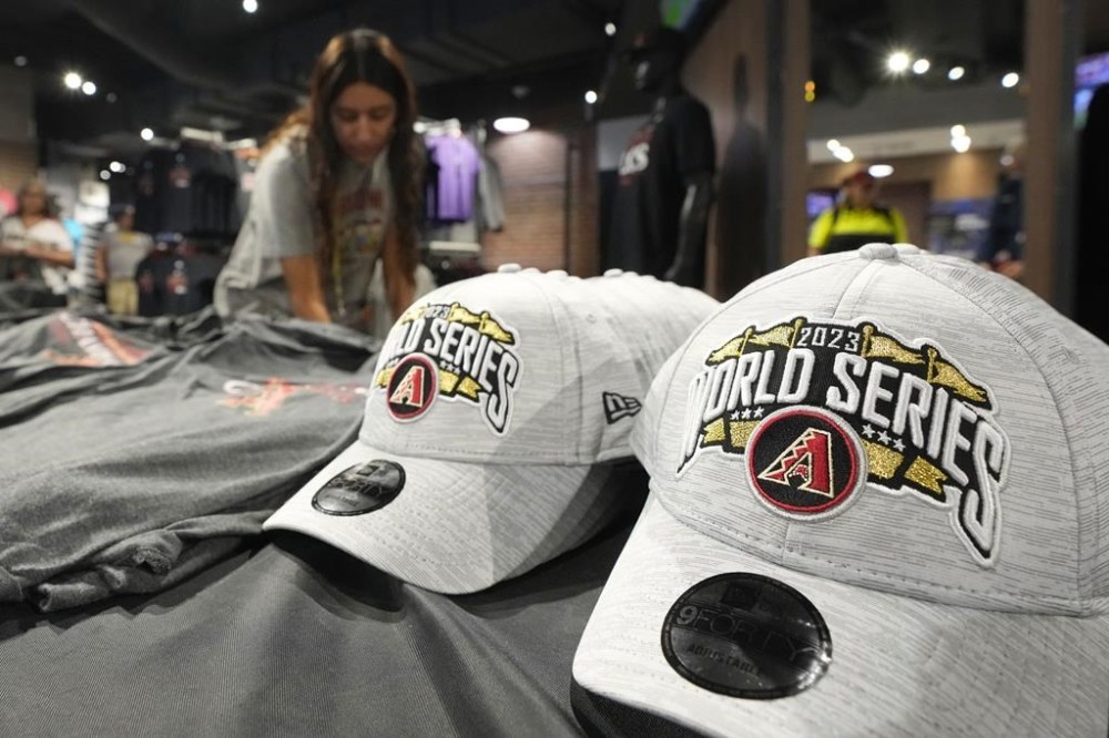 A Chase Field Arizona Diamondbacks team shop employee restocks Diamondbacks World Series baseball hats at Chase Field Wednesday, Oct. 25, 2023, in Phoenix. The Diamondbacks will face the Texas Rangers in Game 1 of the World Series on Friday. (AP Photo/Ross D. Franklin)