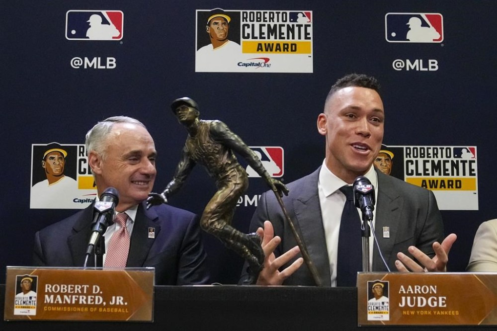 New York Yankees' Aaron Judge, right, speaks as Major League Baseball commissioner Rob Manfred looks on after Judge was named the 2023 Recipient of the Roberto Clemente Award before Game 3 of the baseball World Seriesbetween the Arizona Diamondbacks and the Texas Rangers Monday, Oct. 30, 2023, in Phoenix. (AP Photo/Ross D. Franklin)