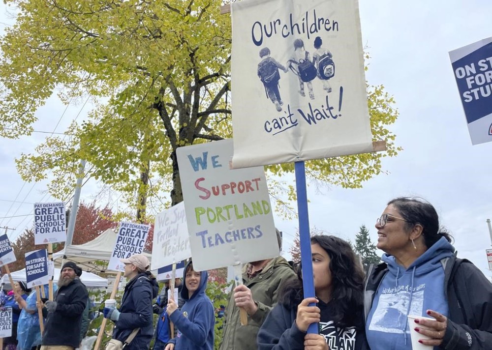 Teachers and their supporters hold signs, chant and rally the crowd on the first day of a teacher's strike in Portland, Ore., Wednesday, Nov. 1, 2023. The Portland Association of Teachers said its first-ever strike in the district stemmed from concerns over large class sizes, salaries that haven't kept up with inflation and a lack of resources. (AP Photo/Claire Rush)