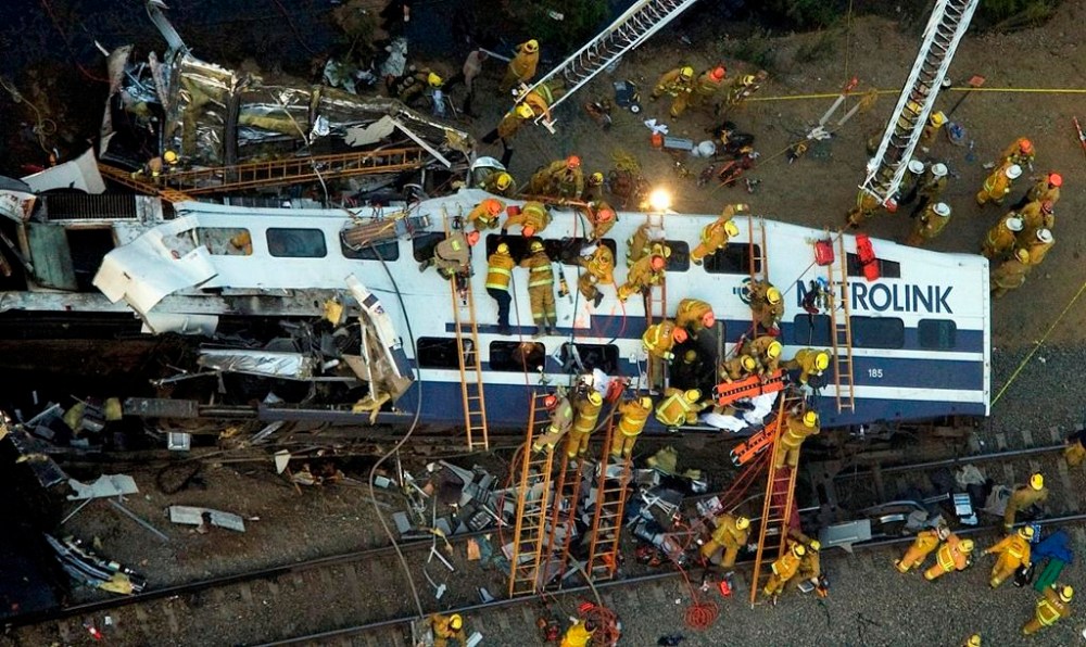 FILE - Rescue personnel work at the scene of a Metrolink commuter train collision in the Chatsworth area of Los Angeles, Friday, Sept. 12, 2008. The National Transportation Safety Board issued a report Wednesday, Nov. 1, 2023, urging the Federal Railroad Administration and the industry to keep developing new technology that can be used to improve Positive Train Control systems. But their recommendations include at least one practical idea that railroads could likely implement relatively quickly. (AP Photo/Hector Mata, File)