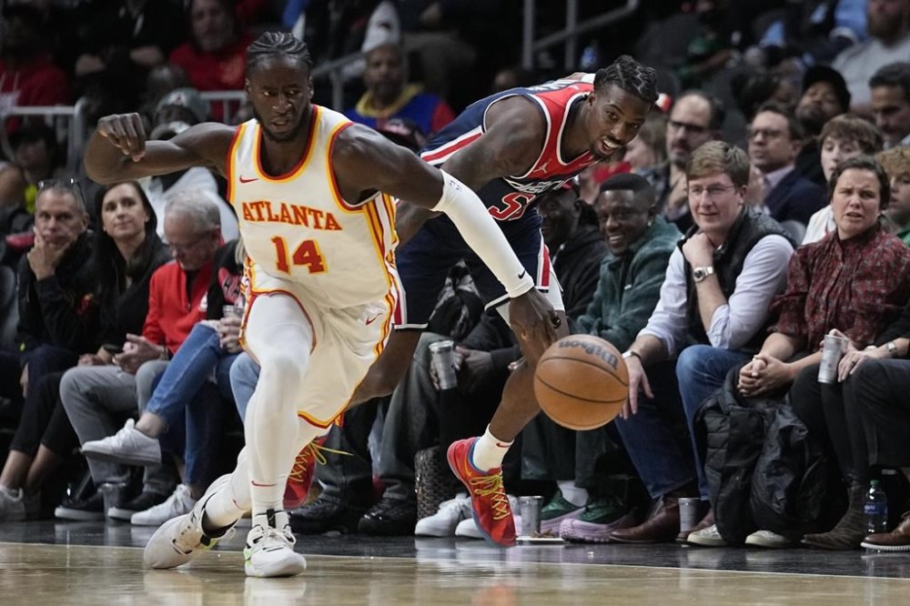 Atlanta Hawks forward AJ Griffin (14) and Washington Wizards guard Delon Wright (55) chase down a loose ball during the first half of an NBA basketball game, Wednesday, Nov. 1, 2023, in Atlanta. (AP Photo/John Bazemore)
