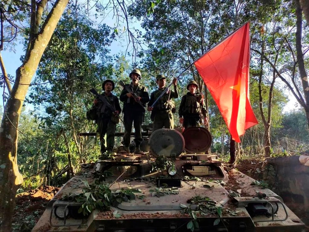 Members of the Myanmar National Democratic Alliance Army hold the group's flag as they pose for a photograph on a captured army armored vehicle in Myanmar, Saturday Oct. 28, 2023. The leader of Myanmar’s army-installed government said the military will carry out counter-attacks against a powerful alliance of ethnic armed groups that has seized towns near the Chinese border in the country’s northeastern and northern regions, state-run media reported Friday Nov. 3, 2023. (