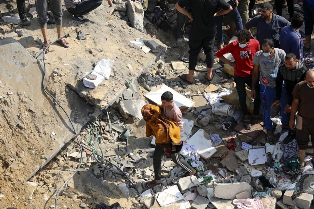 FILE - A Palestinian man carries a dead child that was found under the rubble of a destroyed building, following Israeli airstrikes in Jabaliya refugee camp, northern Gaza Strip, Wednesday, Nov. 1, 2023. Weeks after ordering northern Gaza's 1.1 million inhabitants to evacuate south, the Israeli army is intensifying its bombing of the area that stretches to the wetlands of Wadi Gaza. Israeli soldiers are also battling Hamas militants just north of Gaza City. It's the start of what officials expect to be a long and bloody invasion that has already pinned down hundreds of thousands of Palestinians who remain in the north. (AP Photo/Abed Khaled, File)