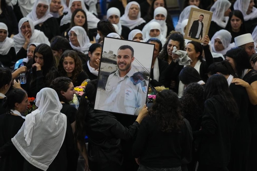 Mourners gather around the flag draped coffin of Druze Israeli Lieutenant colonel Salman Habaka in the village of Yanuh Jat, northern Israel, Friday, Nov. 3, 2023. Habaka was killed during a ground operation in the Gaza Strip. Israeli ground forces have been operating in Gaza in recent days as Israel presses ahead with its war against Hamas militants (AP Photo/Ariel Schalit)