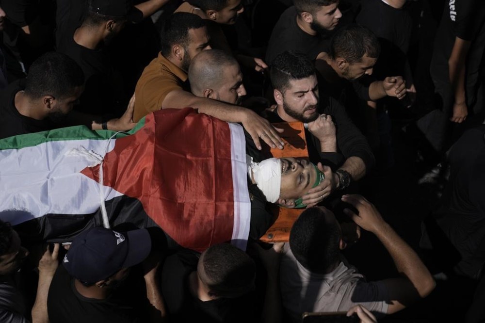 Family members carry Moataz Abu Al-Nada, a Palestinian militant who was killed in an Israeli airstrike on Jenin refugee camp in the West Bank, Friday, Nov. 3, 2023. (AP Photo/Majdi Mohammed)