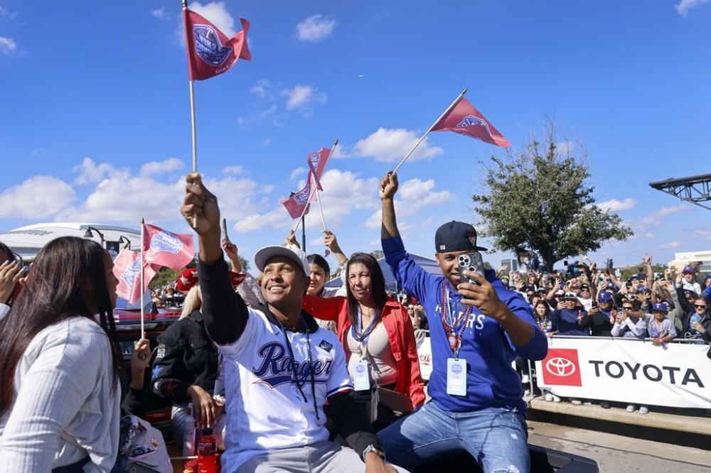 Texas Rangers relief pitcher Jose Leclerc, front, and his family wave flags as they ride in a pickup truck during a parade for the baseball World Series-champion Rangers near Globe Life Field in Arlington, Texas, Friday, Nov. 3, 2023. (Tom Fox/The Dallas Morning News via AP, Pool)