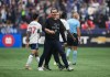 Vancouver Whitecaps head coach Vanni Sartini is restrained by a member of the team's staff after he went on the field and tried to get to referee Tim Ford after he received a red card during the second half in game 2 of a first round MLS playoff soccer match against Los Angeles FC, in Vancouver, on Sunday, November 5, 2023. THE CANADIAN PRESS/Darryl Dyck