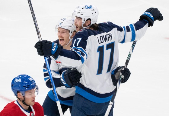 Winnipeg Jets' Adam Lowry (17) celebrates his goal with teammate Mason Appleton (22) as Montreal Canadiens' Jordan Harris (bottom) skates by during second period NHL hockey action in Montreal on Saturday, Oct. 28, 2023. (Christinne Muschi / The Canadian Press)
