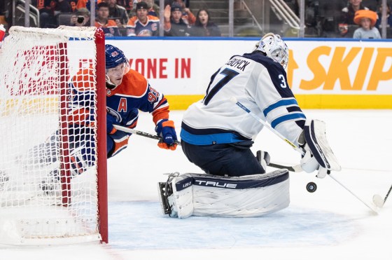 Winnipeg Jets' goalie Connor Hellebuyck (37) makes the save on Edmonton Oilers' Ryan Nugent-Hopkins (93) during overtime NHL action in Edmonton Saturday. (Jason Franson / The Canadian Press)