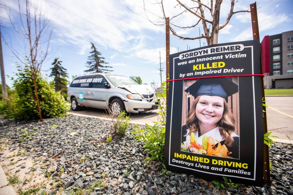 MIKAELA MACKENZIE / WINNIPEG FREE PRESS FILES
An impaired driving awareness vehicle, dropped off by MADD Canada, next to a lawn sign honouring Jordyn Reimer’s memory by Regent Avenue in July.
