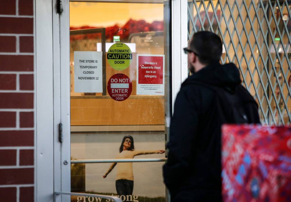A sign on the Shoppers Drug Mart’s door read, ‘This store is temporarily closed due to an emergency.’ (John Woods / Winnipeg Free Press)