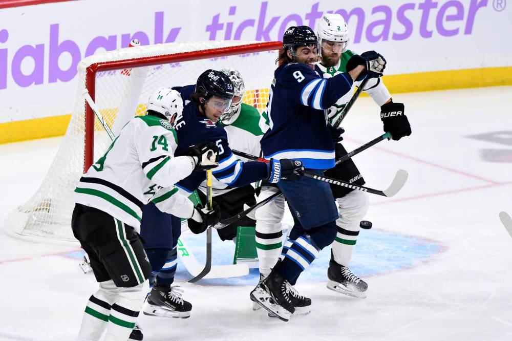 THE CANADIAN PRESS/Fred Greenslade
Winnipeg Jets’ Mark Scheifele, left, tries to deflect a shot on Dallas Stars goaltender Jake Oettinger as Jani Hakanpaa ties up Alex Iafallo during the first period in Winnipeg on Tuesday.
