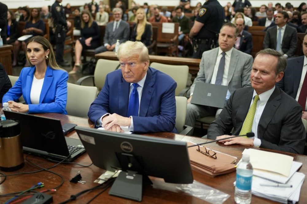 Former President Donald Trump, center, flanked by his defense attorneys, Alina Habba, left, and Chris Kise, waits for the continuation of his civil business fraud trial at New York Supreme Court, Wednesday, Oct. 25, 2023, in New York. (AP Photo/Seth Wenig, Pool)