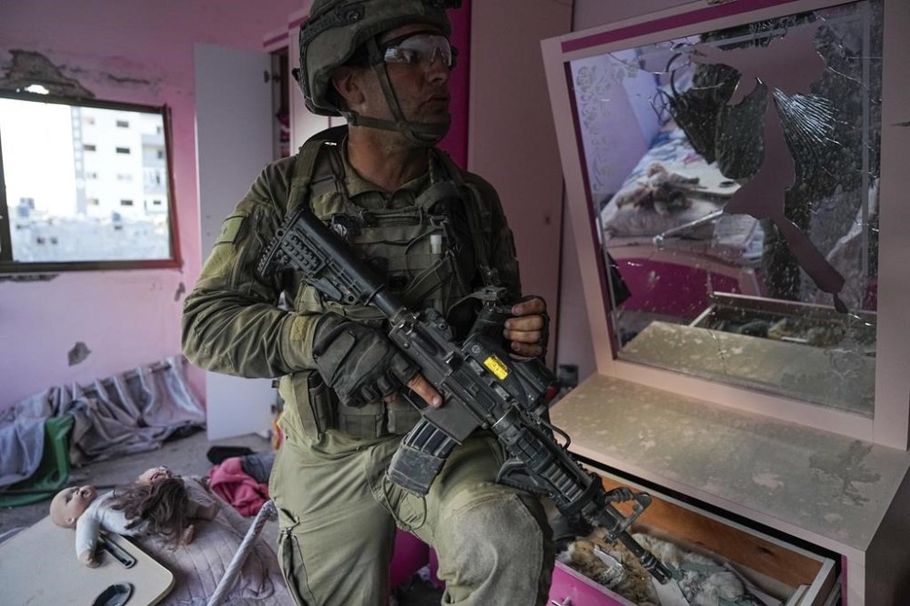 An Israeli soldier stands in an apartment during a ground operation in the Gaza Strip, Wednesday, Nov. 8, 2023. Israeli ground forces entered the Gaza Strip as they press ahead with their war against Hamas militants in retaliation for the group's unprecedented Oct. 7 attack on Israel. (AP Photo/Ohad Zwigenberg)