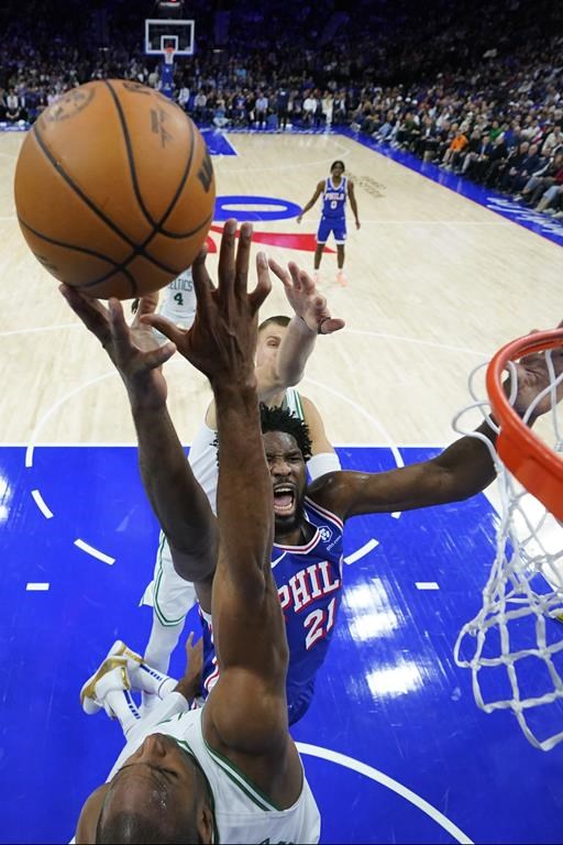 Philadelphia 76ers' Joel Embiid, center, goes up for a shot between Boston Celtics' Al Horford, bottom, and Kristaps Porzingis during the first half of an NBA basketball game, Wednesday, Nov. 8, 2023, in Philadelphia. (AP Photo/Matt Slocum)