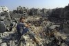 FILE - A man sits on the rubble as others wander among debris of buildings that were targeted by Israeli airstrikes in Jabaliya refugee camp, northern Gaza Strip, Wednesday, Nov. 1, 2023. A new U.N. report paints a stark picture of the devastating collapsing Palestinian economy after a month of war and Israel’s near total siege of Gaza. (AP Photo/Abed Khaled, File)