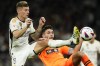 Real Madrid's Toni Kroos, left, and Valencia's Hugo Duro challenge for the ball during the Spanish La Liga soccer match between Real Madrid and Valencia at the Santiago Bernabeu stadium in Madrid, Spain, Saturday, Nov. 11, 2023. (AP Photo/Jose Breton)