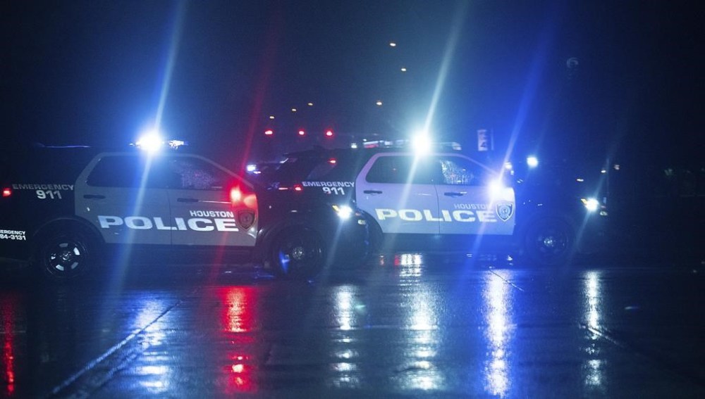 Houston Police cars block access to Main Street near Sam Houston Parkway after a shooting outside Cole's Antique Village and Flea Market, Sunday, Nov. 12, 2023, in Pearland, Texas, near Houston. A manhunt was underway late Sunday after a gunman shot at least five people outside the flea market. The five, identified by police as three adults and two juveniles, were taken to local hospitals, Pearland police said. (Elizabeth Conley/Houston Chronicle via AP)