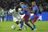 FILE - A-Leagues All Stars' Nestory Irankunda, left, is tackled by Barcelona's Dani Alves, right, and Ronald Araujo during their friendly soccer match in Sydney, Australia, on May 25, 2022. Bayern Munich on Tuesday Nov. 14, 2023 has signed an agreement for 17-year-old Australian winger Nestory Irankunda to join the club in July. (AP Photo/Rick Rycroft, File)