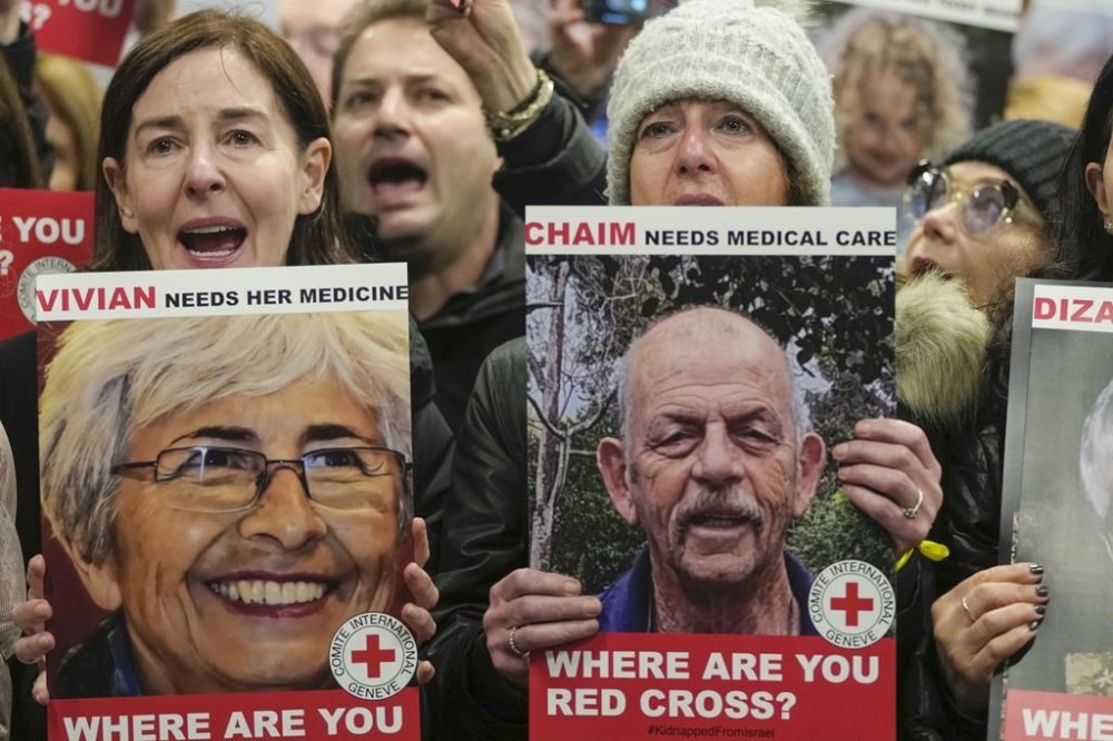 FILE - A person at left holds a poster of Vivian Silver as medical staff and health professionals attend a demonstration in front of the International Committee of the Red Cross (ICRC) in London, Thursday, Nov. 9, 2023, calling for an immediate intervention in the case of the hostages kidnapped from Israel on Oct. 7. Vivian Silver, a Canadian-born Israeli activist who devoted her life to seeking peace with the Palestinians, was confirmed killed in Hamas' Oct. 7 attacks in southern Israel. (AP Photo/Kin Cheung, File)