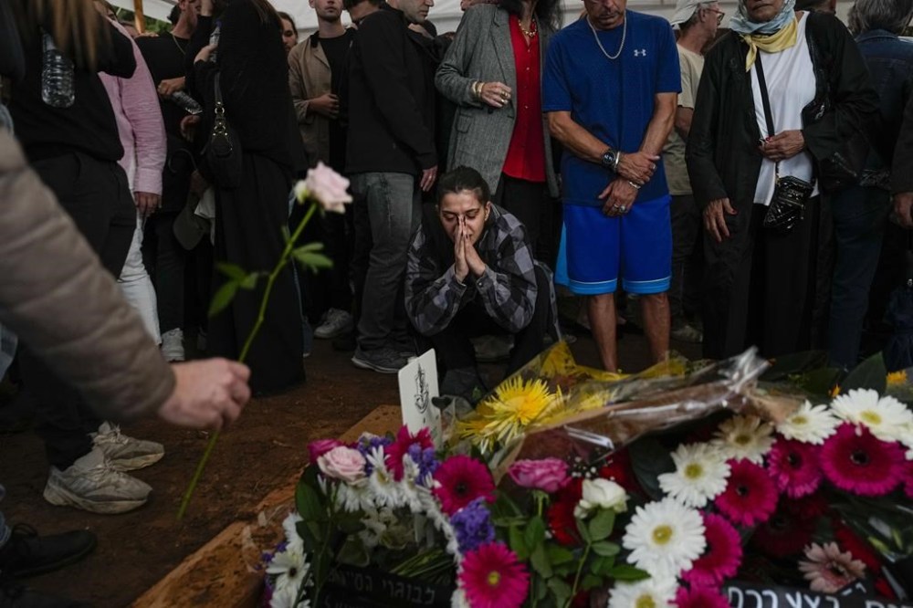 Mourners gather around the grave of Israeli reserve soldier Master sergeant Raz Abulafia at the end of his funeral in the village of Rishpon, Israel, Tuesday, Nov. 14, 2023. Abulafia, 27, was killed during a military ground operation in the Gaza Strip. (AP Photo/Ariel Schalit)