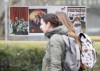 Students walk past a bus shelter where pro-Palestinian posters were taped outside the Université-de-Montréal metro station, in Montreal, Tuesday, Nov., 14, 2023. THE CANADIAN PRESS/Christinne Muschi